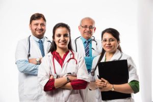 Group of Indian medical doctors, male and female standing isolated on white background, selective focus