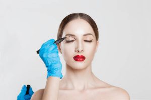 Upper eyelid reduction double eye lid removal plastic surgery cosmetic operation concept Woman eyes closed doctor surgeon hand in gloves drawing cut line eyelid fat isolated white grey background